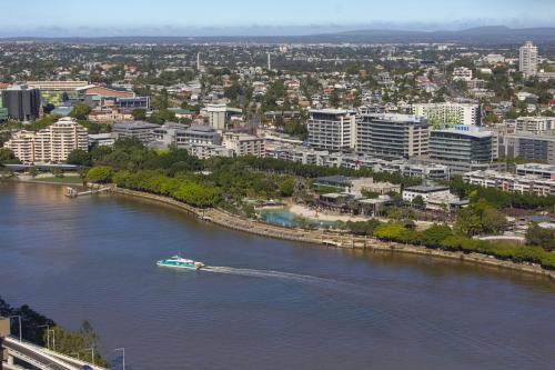 a boat traveling down a river in a city at Oaks Brisbane Casino Tower Suites in Brisbane