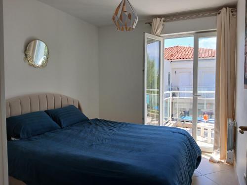 une chambre avec un lit bleu et un balcon dans l'établissement Appartement de luxe 4 pièces Juan Flore, à Antibes