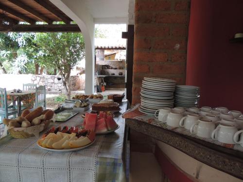 a table with plates and bowls of food on it at Canto Verde Pousada in Lençóis