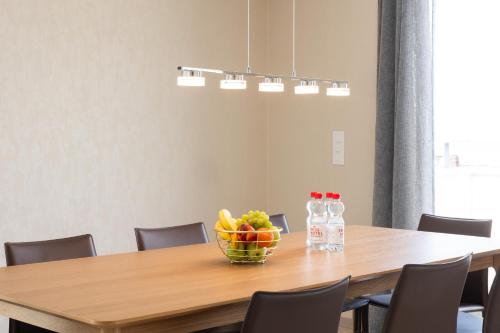 a dining room table with a bowl of fruit and water bottles at Montreux Four Bedroom Penthouse by Swiss Hotel Apartments in Montreux