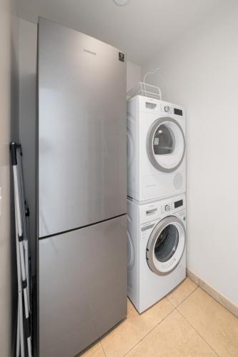 a washer and dryer next to a refrigerator at Montreux Four Bedroom Penthouse by Swiss Hotel Apartments in Montreux