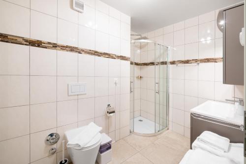 a white bathroom with a shower and a toilet at Montreux Four Bedroom Penthouse by Swiss Hotel Apartments in Montreux