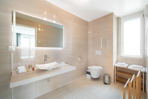 a bathroom with a sink and a toilet at Montreux Four Bedroom Penthouse by Swiss Hotel Apartments in Montreux