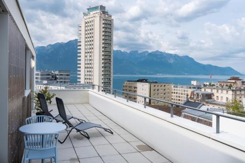 a balcony with two chairs and a table on a building at Montreux Four Bedroom Penthouse by Swiss Hotel Apartments in Montreux