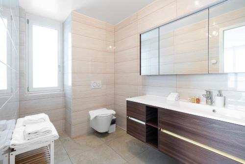 a bathroom with a toilet and a sink at Montreux Four Bedroom Penthouse by Swiss Hotel Apartments in Montreux