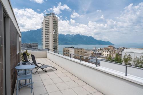 a balcony with two chairs and a table on a building at Montreux Four Bedroom Penthouse by Swiss Hotel Apartments in Montreux
