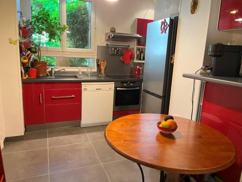- une cuisine avec une table en bois et un bol de fruits dans l'établissement Appartement familial Paris 16 Porte de Saint Cloud, à Boulogne-Billancourt