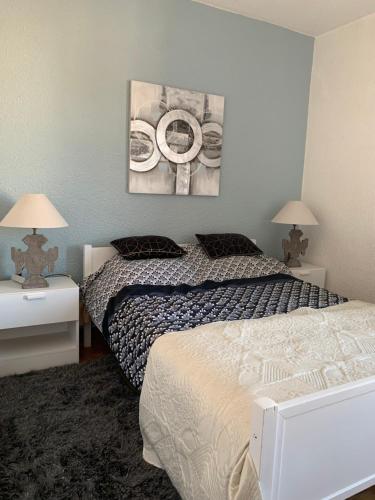 - une chambre avec 2 lits, 2 lampes et un tableau dans l'établissement T5 cap d'agde centre port & piscine, au Cap d'Agde