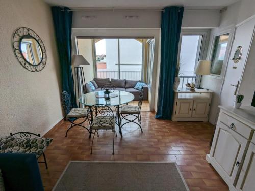 un salon avec une table et un canapé dans l'établissement T5 cap d'agde centre port & piscine, au Cap d'Agde