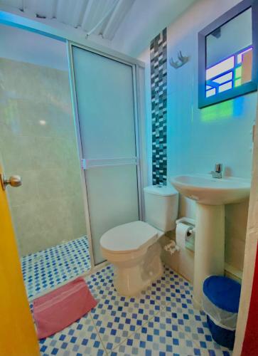 a bathroom with a toilet and a sink at Hotel Marrokos Aeropuerto José María Córdova in Rionegro