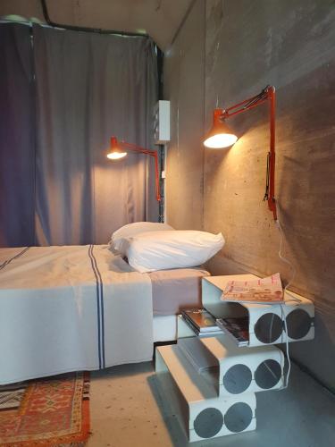 - une chambre avec un lit et une table de chevet avec un lit et une lampe dans l'établissement Un loft original au milieu des vignes, à Lugasson