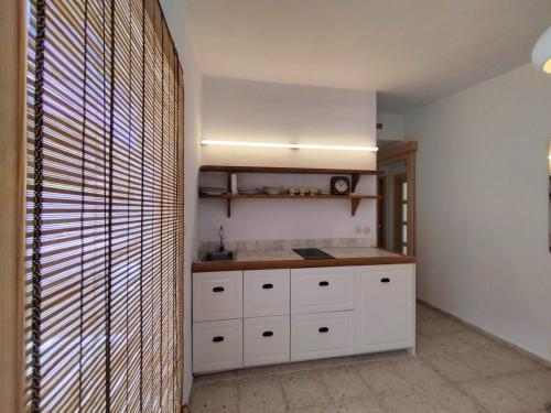 a kitchen with white cabinets and a counter top at La Casita a 60 pasos del mar in Tamaduste