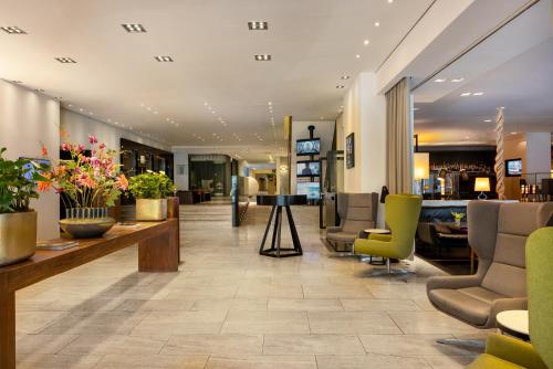 a lobby with chairs and a waiting room at Pullman Eindhoven Cocagne in Eindhoven