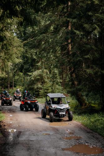 a group of people riding atvs on a dirt road at Transylvania Apartments in Borzont