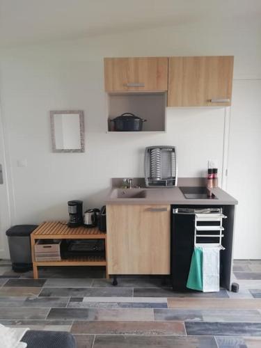 une cuisine avec un évier et un plan de travail dans l'établissement Entre Terre et Mer, à Cairon