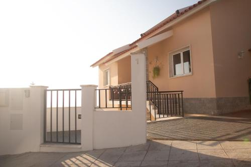 a house with a gate and a balcony at Casa das Flores in Ericeira