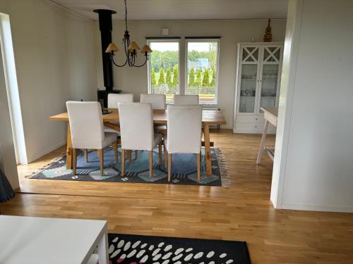a dining room with a table and white chairs at Ausås Ängelholm in Ängelholm