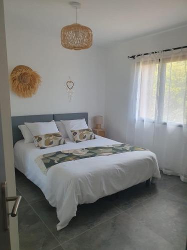 une chambre avec un grand lit blanc et une fenêtre dans l'établissement Casa Albitru, piscine, vue mer et montagne, à Figari