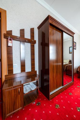a room with a large mirror and a wooden closet at Qibla Tozabog in Khiva