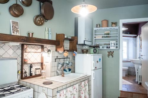 Una cocina con un refrigerador blanco y un fregadero. en Casina di Tufo a 5 minuti da Sorano e Pitigliano, Wi-Fi, en San Quirico