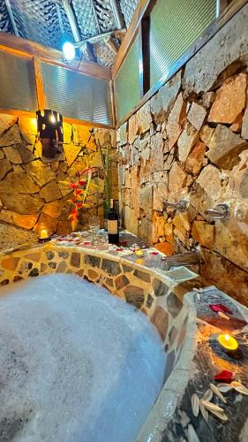 a large bath tub in a stone walled bathroom at Eco Hostal Yuluka in El Zaino