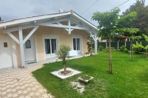une maison avec un petit arbre dans la cour dans l'établissement Maison Solyne Andernos les Bains, à Andernos-les-Bains