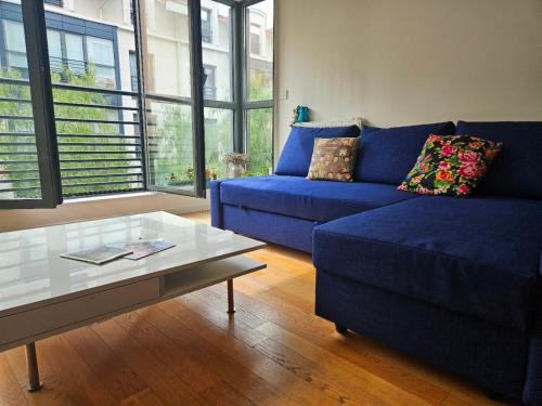 un salon avec un canapé bleu et une table basse dans l'établissement Charmant T2 à la Libération, Nice, à Nice