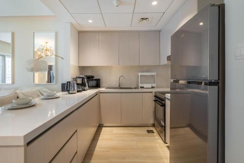 a kitchen with white cabinets and stainless steel appliances at Yas Pearl - 2BD by SLV in Abu Dhabi