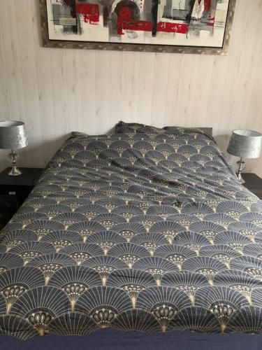 - un lit avec une couette bleue et blanche dans une chambre dans l'établissement Chambres à louer, à Ruaudin