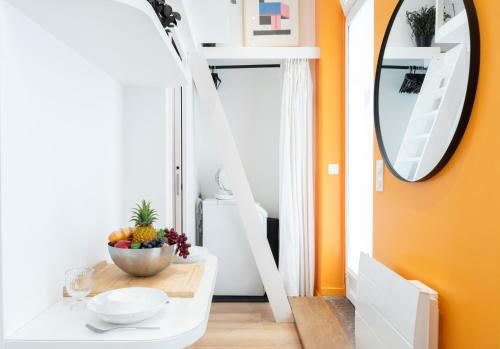 une salle à manger avec une table et un miroir dans l'établissement Lavie Maison Petite Studio, à Paris