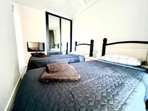 a bedroom with two beds and a mirror at Lovely apartment Esperanto in Benidorm