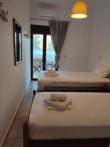 two beds in a room with a view of the ocean at Porto Kagio Villa View in Akhíllion