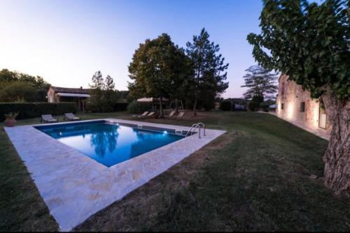 a swimming pool in the yard of a house at Podere Poggiolo in Trequanda