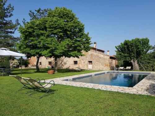 a yard with a swimming pool and a house at Podere Poggiolo in Trequanda