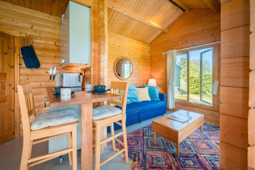 a log cabin with a kitchen and a living room at Little Park Farm Queen Anne Farmhouse & Apartments in Stratfield Mortimer