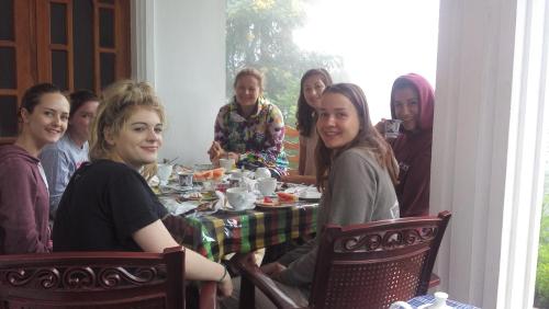 un gruppo di persone sedute attorno a un tavolo di Blue Ribbon Homestay a Ella