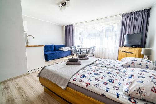 a bedroom with a bed and a blue couch at Niebieska Willa in Jastarnia