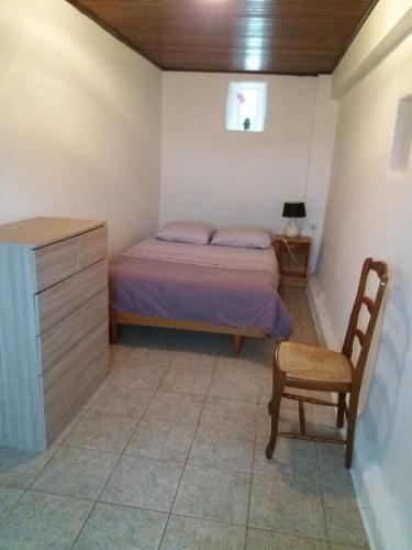 a bedroom with a bed and a chair and a dresser at Village in Sainte-Marguerite-de-Carrouges
