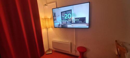 un téléviseur à écran plat accroché au mur dans l'établissement Studio montagne 4 personnes, au Corbier