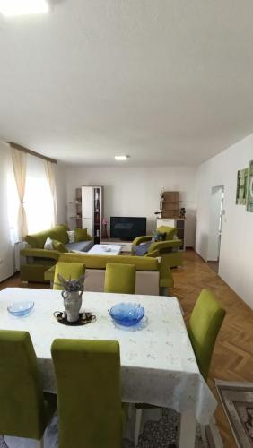 ein Wohnzimmer mit einem Tisch und grünen Stühlen in der Unterkunft Vila AMNA - Ilidža in Doglodi