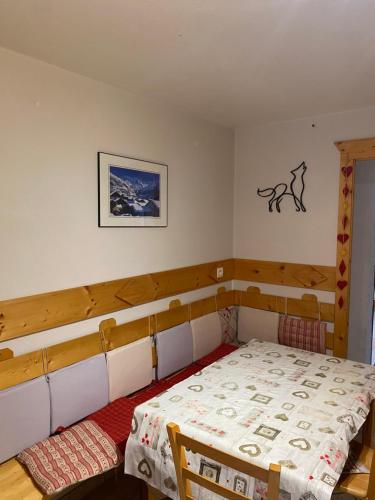 - une petite chambre avec un lit et une photo sur le mur dans l'établissement La faucille, à Praranger