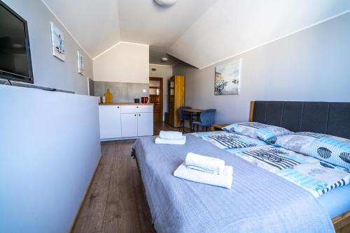 a bedroom with a large bed with towels on it at Niebieska Willa in Jastarnia
