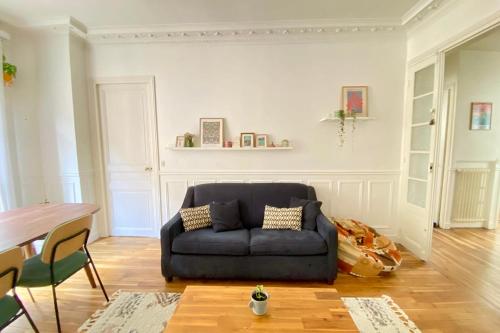 un salon avec un canapé bleu et une table dans l'établissement Splendid apartment near La Villette, à Paris