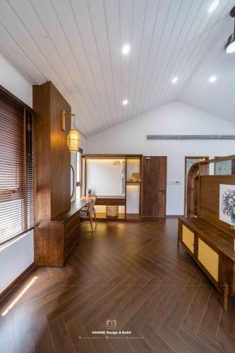 a large room with wooden floors and a white ceiling at Tropicana Hồ Tràm - Seashell Villa in Ho Tram