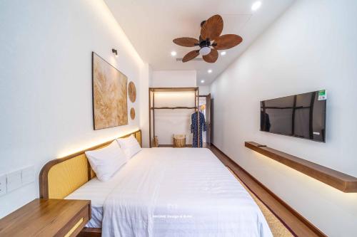 a bedroom with a bed and a flat screen tv at Tropicana Hồ Tràm - Seashell Villa in Ho Tram