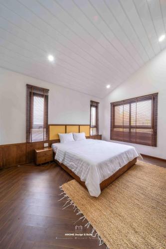 a large bedroom with a large bed and windows at Tropicana Hồ Tràm - Seashell Villa in Ho Tram