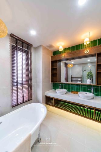 a bathroom with two sinks and a bath tub at Tropicana Hồ Tràm - Seashell Villa in Ho Tram