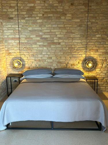 a bedroom with a bed and a brick wall at Vecchio Calzaturificio Verducci in Montegranaro