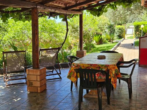 a table and chairs under a pergola on a patio at Case Vacanze Macchione in Capo Vaticano