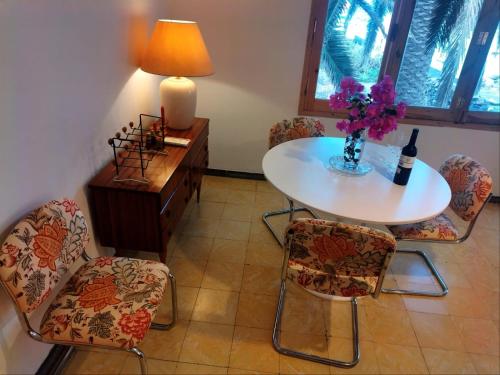 a table and chairs with a vase of flowers on it at La Casita a 60 pasos del mar in Tamaduste